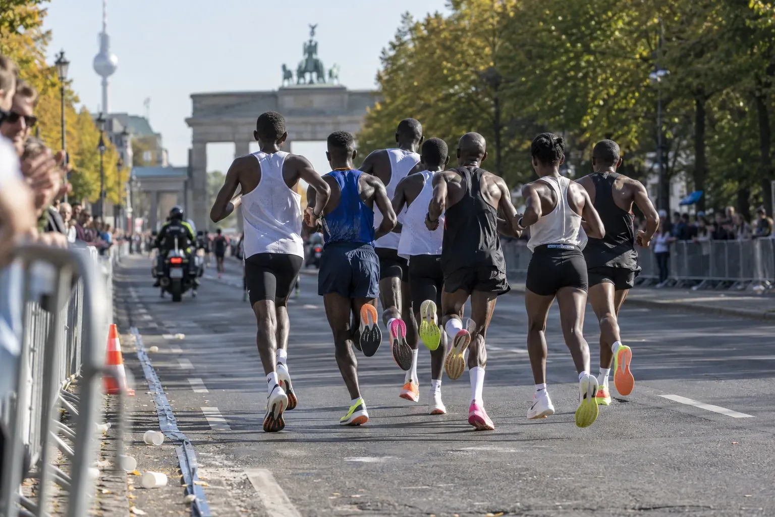 Coureurs adultes de dos dans un peloton de marathon sur une large avenue berlinoise ensoleillée